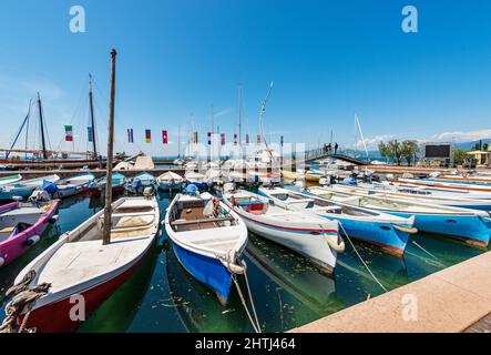 Molte barche da pesca e da diporto ormeggiate nel piccolo porto del villaggio di Bardolino. Località turistica sulla costa del Lago di Garda. Verona, Veneto, Italia. Foto Stock
