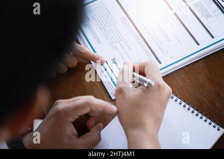 Concetto di firma di prestito, rifinanziamento, acquisto di casa e terra, alloggio in affitto, agente immobiliare femminile o dipendente bancario che indica un contratto o. Foto Stock