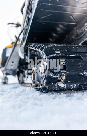 La parte posteriore della motoslitta in inverno. Cavalcare nella neve su una motoslitta. Sospensione posteriore di una motoslitta.motoslitta in condizioni invernali. Pelle estrema Foto Stock