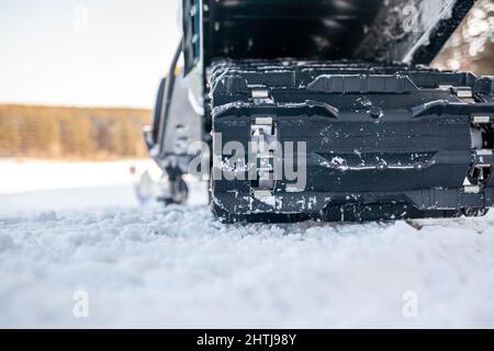 La parte posteriore della motoslitta in inverno. Cavalcare nella neve su una motoslitta. Sospensione posteriore di una motoslitta.motoslitta in condizioni invernali. Pelle estrema Foto Stock