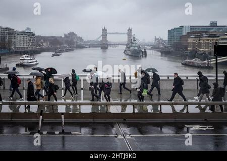 Londra, Regno Unito. 1st marzo 2022. UK Meteo: I pendolari attraversano London Bridge su molto umido e grigio Martedì mattina. Credit: Guy Corbishley/Alamy Live News Foto Stock