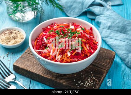 Insalata vitaminica fresca con barbabietole, carote e cavolo condito con aneto e sesamo. Insalata dietetica e vegetariana. Foto Stock