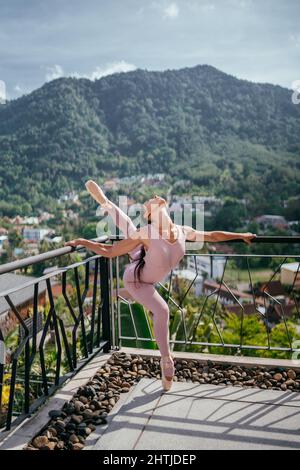 Ballerina giovane in punta contro paesaggio montano Ballerina ballare Foto Stock