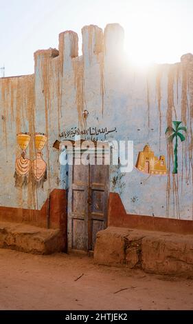 Villaggio nubiano, Egitto - 31 dicembre 2021: Facciata decorata di casa tipica con porta invecchiata in controluce Foto Stock