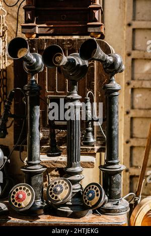 Telefoni nero a candelabro vecchio stile con quadrante posto sul mercato locale vicino edificio sulla strada soleggiata della città in Egitto Foto Stock
