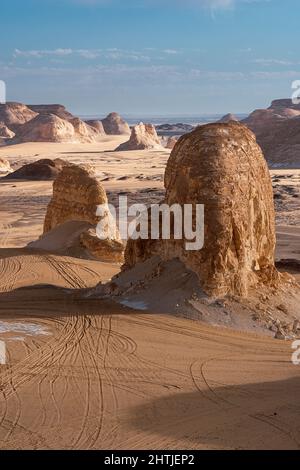 Abbondanza di formazioni rocciose di gesso shabby situate su terreno sabbioso in area protetta di deserto bianco nella giornata di sole in Egitto Foto Stock