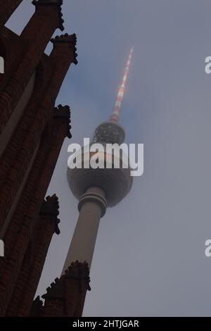 Torre della televisione ad Alexanderplatz visto contro la silhouette di Marienkirche a Berlino, Germania Foto Stock