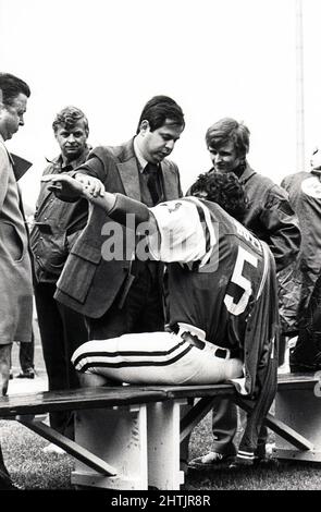 Un chirurgo ortopedico dell'Institute of Sports Medicine & Athletic Trauma esamina il linebacker dei jet di New York Greg Buttle ai margini di una partita dei jet allo Shea Stadium di Flushing Queens. Credo che il suo nome id Dr. Grossman. Circa 1977. Foto Stock