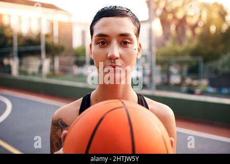 Ive ha fatto il mio volto di gioco. Scatto corto di un giovane sportivo attraente in piedi sul campo da solo e tenendo una pallacanestro durante il giorno. Foto Stock