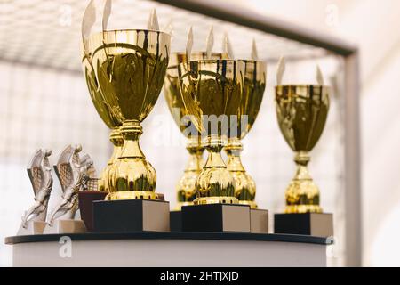 Foto di un set di trofei dorati in piedi sul tavolo. Coppe d'oro per i vincitori del concorso sportivo Foto Stock