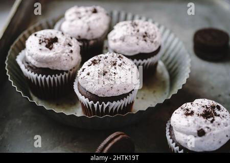 Biscotti e cupcake alla crema senza glassa montata, fuoco selettivo Foto Stock