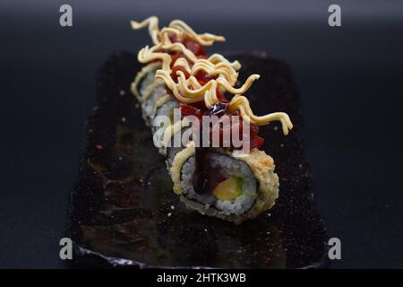 Combinazione colorata di tradizionale rotolo di sushi giapponese Uramaki con. Vista frontale. Foto Stock