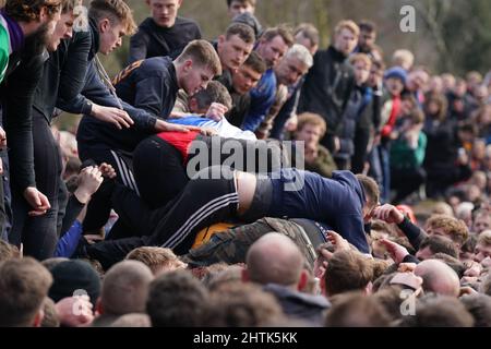 I giocatori partecipano alla Royal Shrovetide Football Match di Ashbourne, Derbyshire, che si svolge in città dal 12th secolo. Data foto: Martedì 1 marzo 2022. Foto Stock