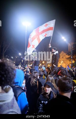 27 febbraio 2022, Georgia: A Tbilisi, un manifestante sventola una bandiera georgiana sopra la folla di manifestanti che si levano a sostegno dell'Ucraina di fronte al Parlamento della Georgia nel 4th giorno di proteste contro l'invasione russa dell'Ucraina. (Credit Image: © Aurelien Foucault/ZUMA Press Wire) Foto Stock