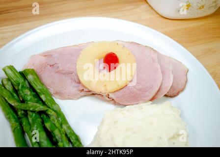 Primo piano di una deliziosa cena al Ham con purè di patate e asparagi freschi al vapore Foto Stock