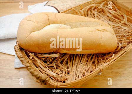 Un solo pane di pane fresco lasciato in un paniere rustico Foto Stock