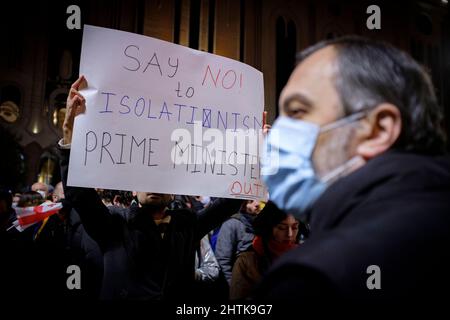 28 febbraio 2022, Georgia: A Tbilisi, un manifestante ha un segno davanti al Parlamento della Georgia il 5th giorno di proteste contro l'invasione russa dell'Ucraina. I segnali chiedono le dimissioni del primo ministro della Georgia, Irakli Garibashvili, per aver rifiutato di applicare sanzioni alla Russia e per aver rifiutato di lasciare che i combattenti georgiani volontari volino per assistere l'Ucraina. (Credit Image: © Aurelien Foucault/ZUMA Press Wire) Foto Stock