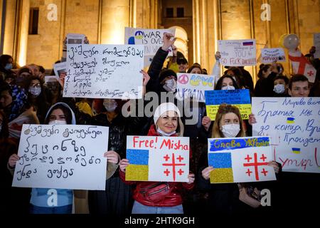 28 febbraio 2022, Georgia: A Tbilisi, i manifestanti si trovano di fronte al Parlamento della Georgia il 5th giorno di proteste contro l'invasione russa dell'Ucraina. I segni criticano il primo ministro georgiano Irakli Garibashvili e chiedono di liberare l'ex presidente Mikheil Saakashvili, mentre desiderano gloria all'Ucraina. (Credit Image: © Aurelien Foucault/ZUMA Press Wire) Foto Stock