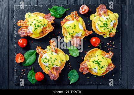 Metà di un muffin inglesi, ciascuno con pancetta canadese, un uovo in camicia, e salsa di hollandaise, uova Benedetto Foto Stock