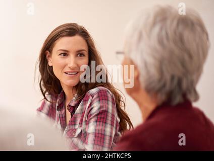 Lei ammira la madre. Colpo di una donna attraente che si lega con la sua madre anziana a casa. Foto Stock