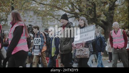 Londra, UK - 11 20 2021: Una donna anziana che porta un cartello, “tradita dal mio governo”, in una marcia insulata della Gran Bretagna sulla strada per Lambeth Bridge. Foto Stock