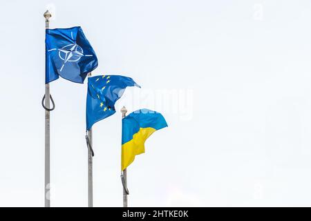 Vilnius, Lituania - Febbraio 16 2022: Bandiera della NATO, dell'Unione europea e dell'Ucraina che ondeggiavano insieme nel cielo, spazio copia Foto Stock
