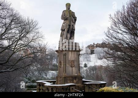 Il monumento Allan Ramsay e i giardini Princes Street nella neve, Edimburgo, Scozia Foto Stock