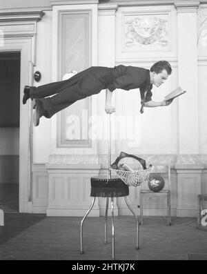 Uomo di talento nel 1950s. Il regista svedese Jan Lindblad, 1932-1987, era anche un giocoliere e un acrobata di talento e si vede qui esibirsi con il suo atto di equilibrarsi solo sul braccio destro e leggere un libro allo stesso tempo. Svezia 1955 Kristoffersson Ref BU90-10 Foto Stock