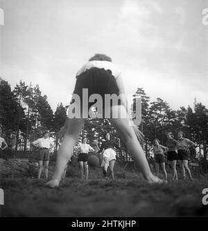 Nel 1950s. Una squadra di calcio femminile durante la pratica. Uno ad uno sparano la palla al portiere che è raffigurato da dietro. Svezia 1951 Kristoffersson BE37-10 Foto Stock