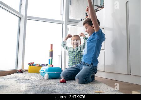 Due ragazzi allegri che giocano con blocchi da costruzione Foto Stock