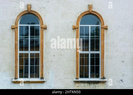 Due vecchie finestre ad arco sullo sfondo di una vecchia parete grigia. Dalla serie Windows of the World. Foto Stock