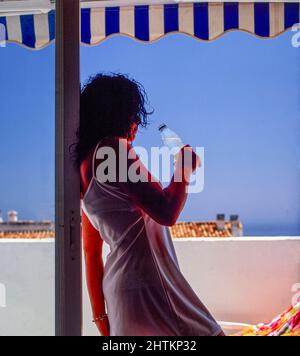 Sana; signora semi-silhouted che gode acqua in bottiglia Foto Stock