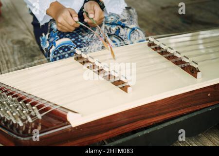 Ragazza thailandese che suona Khim, il tradizionale strumento musicale thailandese. Tempo libero e hobby Foto Stock