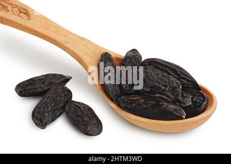 Fagiolo Tonka in cucchiaio di legno isolato su sfondo bianco con percorso di taglio e profondità di campo. Fagiolo di Dipteryx odorata Foto Stock