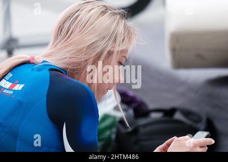 Antalya, Turchia Ottobre 31 2021: Ciclista russa che controlla il suo telefono all'area di servizio di Ironman 70,3. Foto Stock