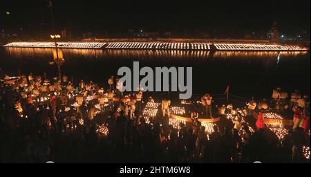 Ujjain, India. 01st Mar 2022. I devoti illuminano le lampade sulle rive del fiume santo Kshipra per stabilire un nuovo record mondiale di illuminazione 2,1million lampade in occasione del festival Maha Shivratri. Il governo dello Stato di Madhya Pradesh sta cercando di creare un nuovo record nel Guinness Book illuminando 2,1 milioni di lampade in terra nella città Santa infrangendo il record precedente di 9, 45.600 lampade ad Ayodhya in occasione di Diwali. Credit: SOPA Images Limited/Alamy Live News Foto Stock