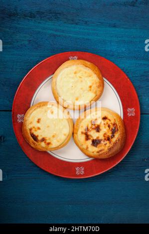 Vatrushki fatto in casa, piccole torte russe con formaggio casereccio su sfondo blu scuro verticale Foto Stock