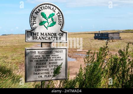 Firma del National Trust per il Maniero di Brancaster a Brancaster Staithe sulla costa nord del Norfolk. Foto Stock