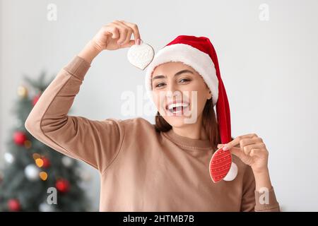 Bella donna a Santa Hat con biscotti di pan di zenzero a casa Foto Stock