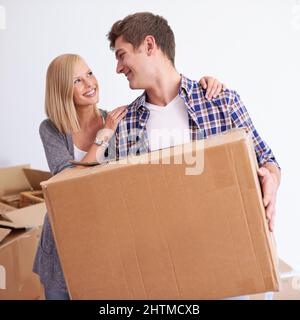 Così felice finalmente ci siamo trasferiti nella nostra nuova casa. Scatto di una giovane coppia felice sul loro movimento di giorno. Foto Stock