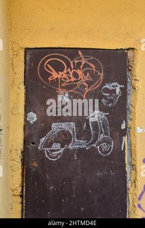Disegni e graffiti su una porta in metallo arrugginito nel centro storico di Sanremo, Imperia, Liguria, Italia Foto Stock