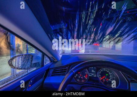 Auto in autolavaggio automatico, linea autolavaggio, schiuma detergente spruzzata, spazzole rotanti pulire il veicolo, Foto Stock