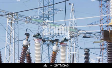 Poli di potenza sullo sfondo del cielo blu. Azione. Bellissimi poli elettrici su sfondo cielo blu. Sottostazione elettrica con poli e cavi. Generazione di energia Foto Stock