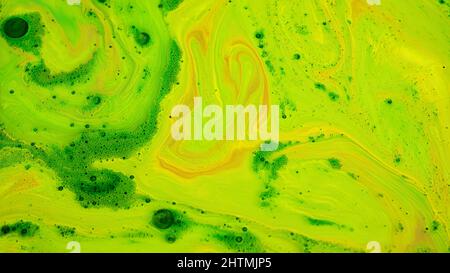 Miscelazione di vernici acide. Riprese in stock. Gli inchiostri acidi brillanti di colori diversi vengono miscelati in corrente sulla superficie del liquido. Vernici acide e spesse creano patte Foto Stock