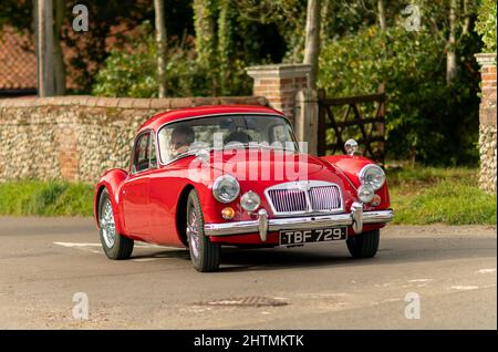 1962 MG Una MkII Coupé in rosso sulle strade del villaggio di Norfolk Nord, Regno Unito Foto Stock