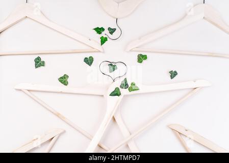 Hangers con piante su sfondo bianco con copy space.consupmtion rispettoso dell'ambiente in shopping.Recycling o zero concetto di spreco Foto Stock