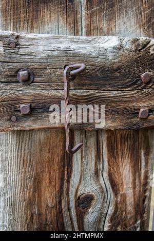 serratura a gancio in ferro ritorto sulla porta del fienile in legno Foto Stock