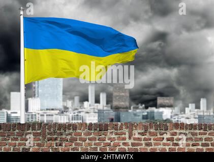 Bandiera Ucraina su un muro di mattoni di un edificio. Bandiera Ucraina nel cielo di nuvole nere tempesta. Foto Stock