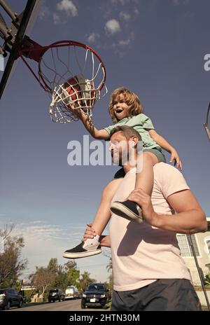 fathr e figlio giocano a basket ball all'aperto sul parco giochi sportivo, sport Foto Stock