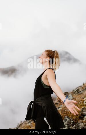 Canada, Whitehorse, Donna con occhi chiusi e braccia distese nel paesaggio Foto Stock